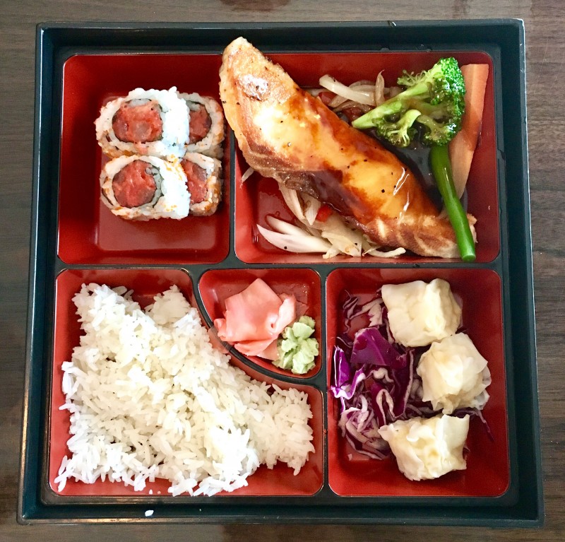 Bento box with teriyaki salmon, shumai, sushi and white rice