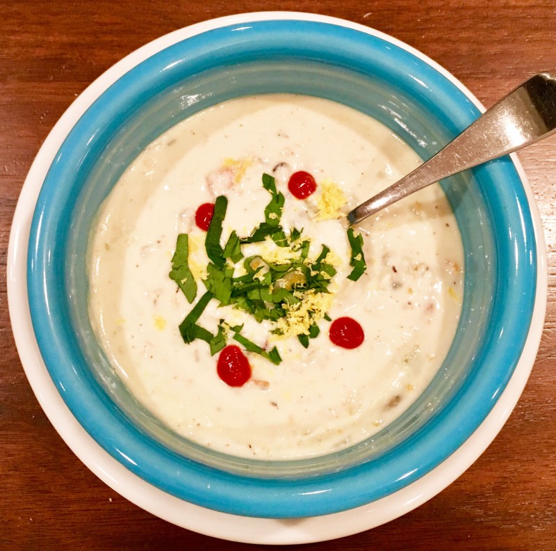 dairy free clam chowder in bowl with Sriracha, parsley and lemon zest